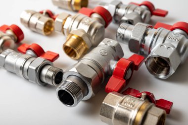 Pirinç, kırmızı vanalı metal su muslukları, farklı, arka planda izole, yakın plan, tesisat bağlantısı 