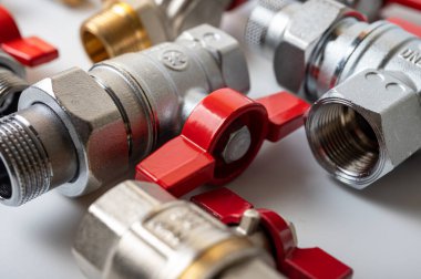 Pirinç, kırmızı vanalı metal su muslukları, farklı, arka planda izole, yakın plan, tesisat bağlantısı 