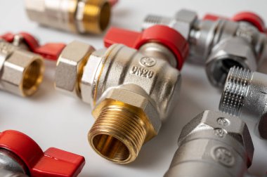Pirinç, kırmızı vanalı metal su muslukları, farklı, arka planda izole, yakın plan, tesisat bağlantısı 