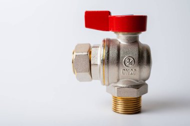 Pirinç rengi metal musluk, kırmızı kapakçık, farklı açı, arka planda izole, yakın plan, tesisat bağlantısı.