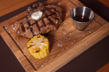 Izgarada, ahşap tepside mısırla kavrulmuş sulu bir et parçası. Lezzetli yemek.