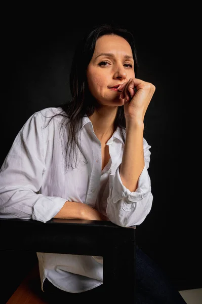 Retrato Emocional Cerca Una Niña Sentada Una Silla Oscura Sosteniendo —  Fotos de Stock