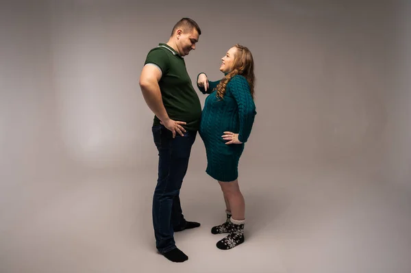 남자와 임산부가 그들의 농담을 있습니다 스튜디오 인테리어 배경에 고립됨 — 스톡 사진