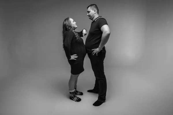 남자와 임산부가 그들의 농담을 손으로 있습니다 스튜디오 인테리어 배경에 고립되어 — 스톡 사진