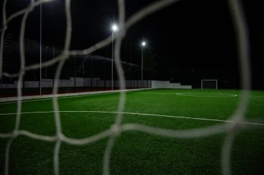 Futbol, futbol, voleybol, akşam stadyumu ve yapay ışıklandırma için yeşil çimen arka planı. Yeşil çimen deseni ve doku arkaplanı. Resmi kapat.
