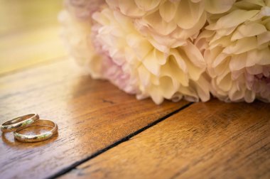 Tahta bir yüzükte alyans ve düğün çiçeklerinin yanında bir yüzük, nişan konsepti, bir aile yaratmak, seçici bir odak noktası.