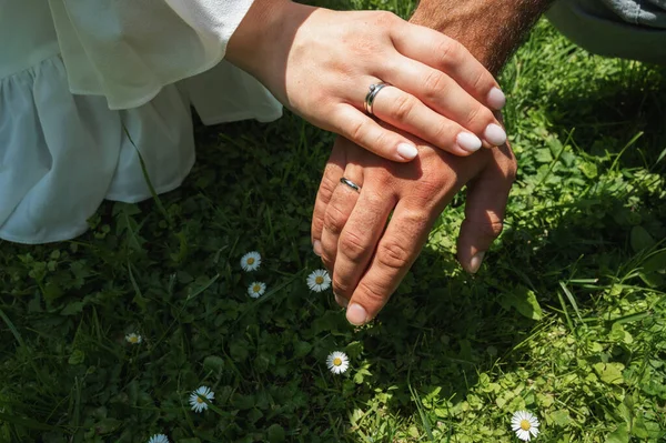 Hands and hearts together. A close-up of a loving couple holding hands while walking outdoors in a park