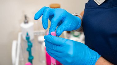 Bir doktor hastanın kulak kanalını işitme kliniğinde kulak tıkaçları yapmak için şırınga kullanılarak yapılan silikon bir maddeyle dolduruyor. Düzenlenecek eklerin üretimi