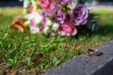 Düğün buketi ve alyans ön planda. Bir aile yaratmak, bir poster için arka plan