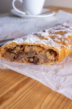 Elma ve tarçınla doldurulmuş lezzetli meyveli turta parçaları hafif bir arka planda hafif bir tabakta. Yazmak için yer var. Manzarayı kapat. Ev yapımı Ukrayna hamur işleri