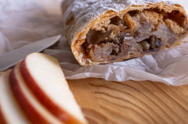 Elma ve tarçınla doldurulmuş lezzetli meyveli turta parçaları hafif bir arka planda hafif bir tabakta. Yazmak için yer var. Manzarayı kapat. Ev yapımı Ukrayna hamur işleri