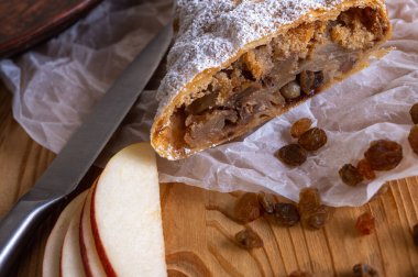 Elma ve tarçınla doldurulmuş lezzetli meyveli turta parçaları hafif bir arka planda hafif bir tabakta. Yazmak için yer var. Manzarayı kapat. Ev yapımı Ukrayna hamur işleri