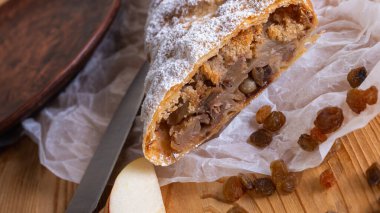 Elma ve tarçınla doldurulmuş lezzetli meyveli turta parçaları hafif bir arka planda hafif bir tabakta. Yazmak için yer var. Manzarayı kapat. Ev yapımı Ukrayna hamur işleri