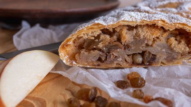 Elma ve tarçınla doldurulmuş lezzetli meyveli turta parçaları hafif bir arka planda hafif bir tabakta. Yazmak için yer var. Manzarayı kapat. Ev yapımı Ukrayna hamur işleri