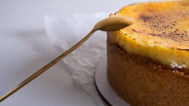 Kabuklu peynirli kek, bir parça kesilmiş, hafif bir tabakta, arka planda. Pasta, hamur işi.