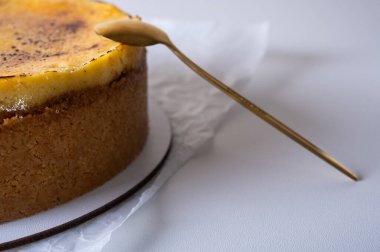 Kabuklu peynirli kek, bir parça kesilmiş, hafif bir tabakta, arka planda. Pasta, hamur işi.