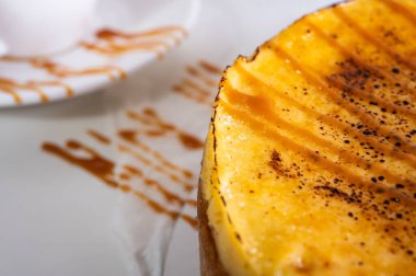 Kabuklu peynirli kek, bir parça kesilmiş, hafif bir tabakta, arka planda. Pasta, hamur işi.