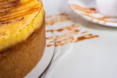 Kabuklu peynirli kek, bir parça kesilmiş, hafif bir tabakta, arka planda. Pasta, hamur işi.