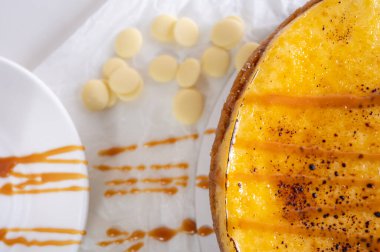 Kabuklu peynirli kek, bir parça kesilmiş, hafif bir tabakta, arka planda. Pasta, hamur işi.