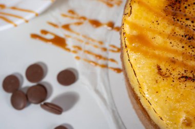 Kabuklu peynirli kek, bir parça kesilmiş, hafif bir tabakta, arka planda. Pasta, hamur işi.