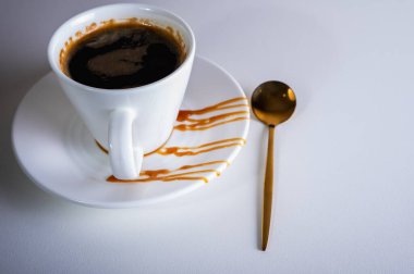 Hafif bir arka planda bir fincan kahve, hafif bir çanakta yakın plan bir görüntü. 