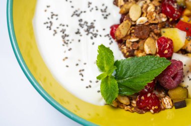 meyve, armutlu vejetaryen salatası, ahududu, beyaz arka planda renkli bir tabakta pullar. Hafif kahvaltı, sabah