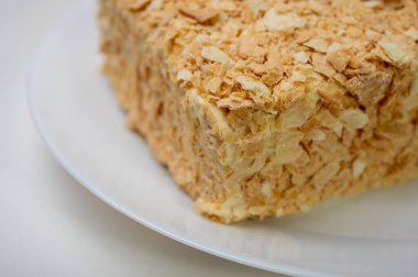 Yakın görüş, açık yüzeyde Napolyon pastası, beyaz tabak, yan görüş. Yazı için yer