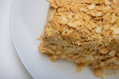 Yakın görüş, açık yüzeyde Napolyon pastası, beyaz tabak, yan görüş. Yazı için yer