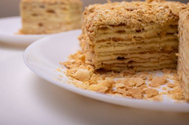 Yakın görüş, açık yüzeyde Napolyon pastası, beyaz tabak, yan görüş. Yazı için yer