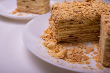 Yakın görüş, açık yüzeyde Napolyon pastası, beyaz tabak, yan görüş. Yazı için yer