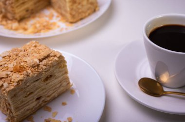 Yakın görüş, açık yüzeyde Napolyon pastası, beyaz tabak, yan görüş. Yazı için yer