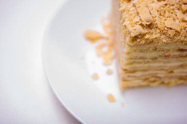 Yakın görüş, açık yüzeyde Napolyon pastası, beyaz tabak, yan görüş. Yazı için yer