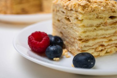 Yakın görüş, açık yüzeyde Napolyon pastası, beyaz tabak, yan görüş. Yazı için yer