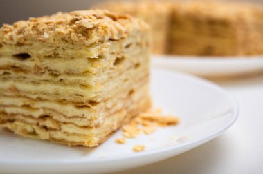 Yakın görüş, açık yüzeyde Napolyon pastası, beyaz tabak, yan görüş. Yazı için yer