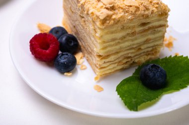 Yakın görüş, açık yüzeyde Napolyon pastası, beyaz tabak, yan görüş. Yazı için yer