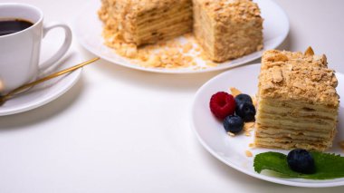 Yakın görüş, açık yüzeyde Napolyon pastası, beyaz tabak, yan görüş. Yazı için yer