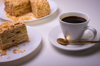 Yakın görüş, açık yüzeyde Napolyon pastası, beyaz tabak, yan görüş. Yazı için yer
