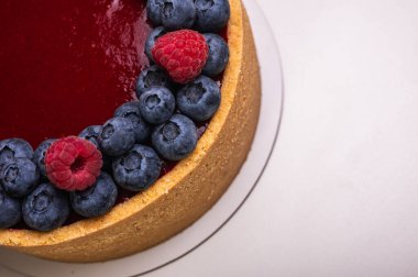 Üst manzara, peynirli cheesecake yakın plan taze böğürtlen, böğürtlen ve ahududu ile süslenmiş hafif arka plan, metin için yer