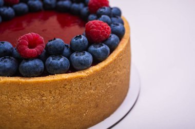 Üst manzara, peynirli cheesecake yakın plan taze böğürtlen, böğürtlen ve ahududu ile süslenmiş hafif arka plan, metin için yer