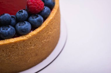 Üst manzara, peynirli cheesecake yakın plan taze böğürtlen, böğürtlen ve ahududu ile süslenmiş hafif arka plan, metin için yer