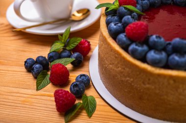 Üst manzara, taze böğürtlen, böğürtlen ve ahududu ile süslenmiş peynirli cheesecake yakın plan, yazı için yer. Şenlikli görünüm