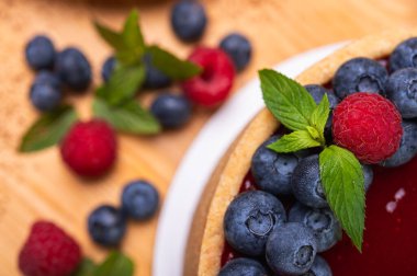 Üst manzara, taze böğürtlen, böğürtlen ve ahududu ile süslenmiş peynirli cheesecake yakın plan, yazı için yer. Şenlikli görünüm