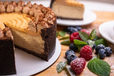 Kremalı cheesecake yakın plan, taze böğürtlen, yabanmersini ve ahududu ile süslenmiş, bayramlık yeni yıl pastası, Noel