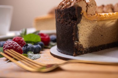 Kremalı cheesecake yakın plan, taze böğürtlen, yabanmersini ve ahududu ile süslenmiş, bayramlık yeni yıl pastası, Noel