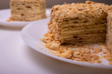 Yakın görüş, açık yüzeyde Napolyon pastası, beyaz tabak, yan görüş. Yazı için yer