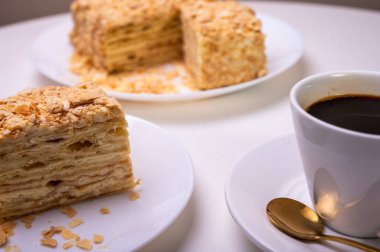 Yakın görüş, açık yüzeyde Napolyon pastası, beyaz tabak, yan görüş. Yazı için yer