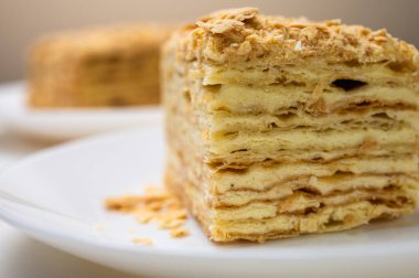 Yakın görüş, açık yüzeyde Napolyon pastası, beyaz tabak, yan görüş. Yazı için yer