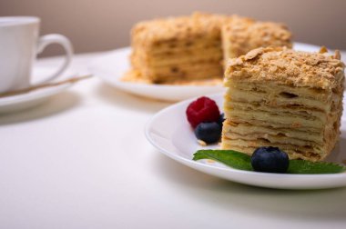 Yakın görüş, açık yüzeyde Napolyon pastası, beyaz tabak, yan görüş. Yazı için yer