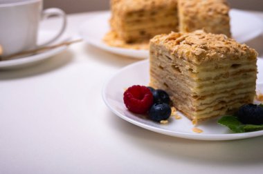 Yakın görüş, açık yüzeyde Napolyon pastası, beyaz tabak, yan görüş. Yazı için yer