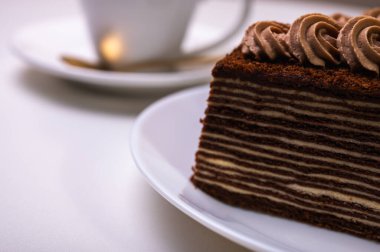 Çayla çikolatalı kek, bir parça kıvılcımla kahve, hafif bir arka planda..